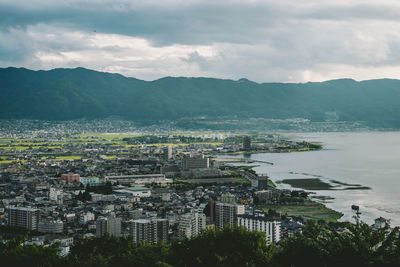 High angle view of townscape by sea against sky