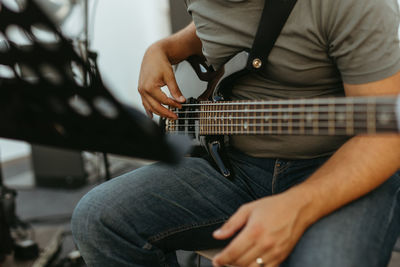 Midsection of man playing guitar