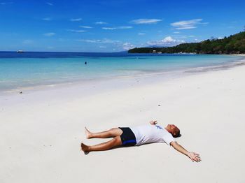 Low section of person on beach against sky