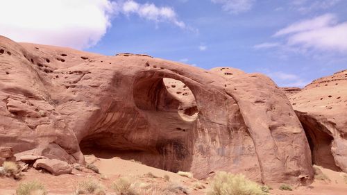 Rock formations in desert against cloudy sky