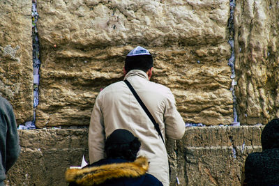 Rear view of man standing against wall