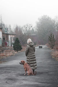 Side view of woman with dog on street