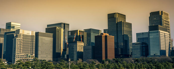 Skyscrapers in tokyo city against sky during sunset