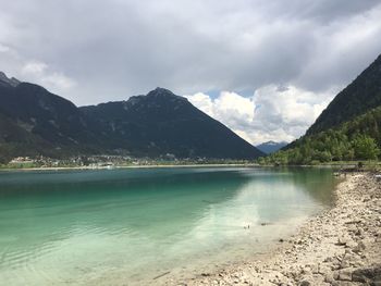 Scenic view of lake by mountains against sky