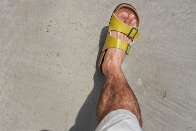 Low section of man standing on beach