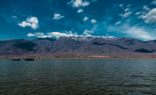 Scenic view of sea and mountains against sky