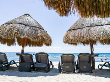 Chairs and parasols on beach against sky