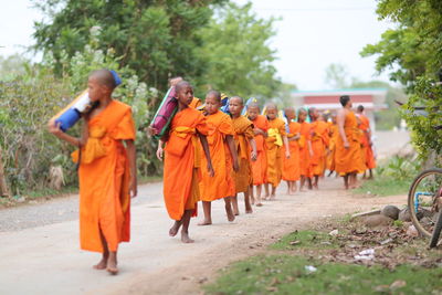 People walking on street against trees