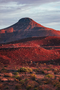 Sunset of red desert of damaraland with mountain in background in namibia.