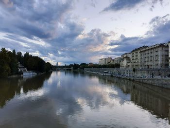 River by buildings in city against sky