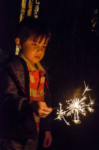 Boy looking at firework display at night