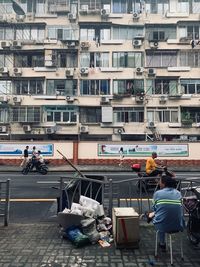 People on street against buildings in city