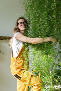 Portrait of smiling woman standing against plants