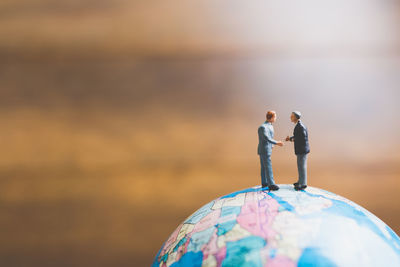 Figurines on globe over table