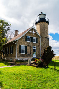 Old building by field against sky