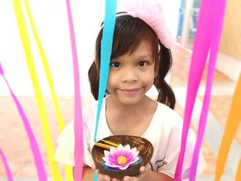 Portrait of smiling girl standing against wall