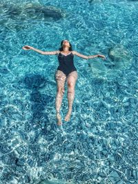 High angle view of woman relaxing in swimming pool