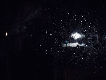 Close-up of illuminated water against sky at night