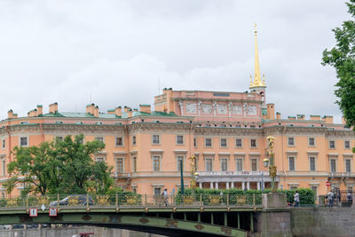 Buildings in city against cloudy sky