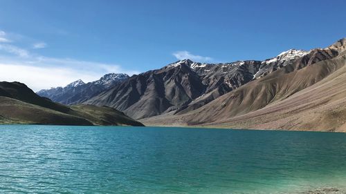 Scenic view of lake and mountains against blue sky