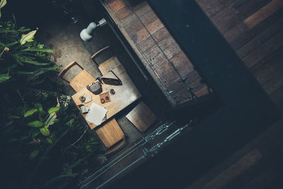 Top view a table with a cup of coffee and camera bag at coffee shop style nature garden