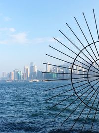 Modern buildings by sea against blue sky