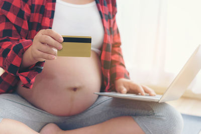 Midsection of girl using mobile phone