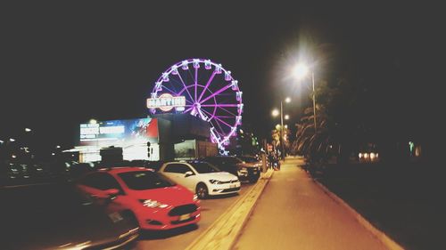 Illuminated ferris wheel at night