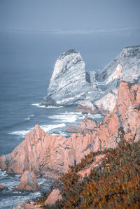 Rock formations in sea against sky