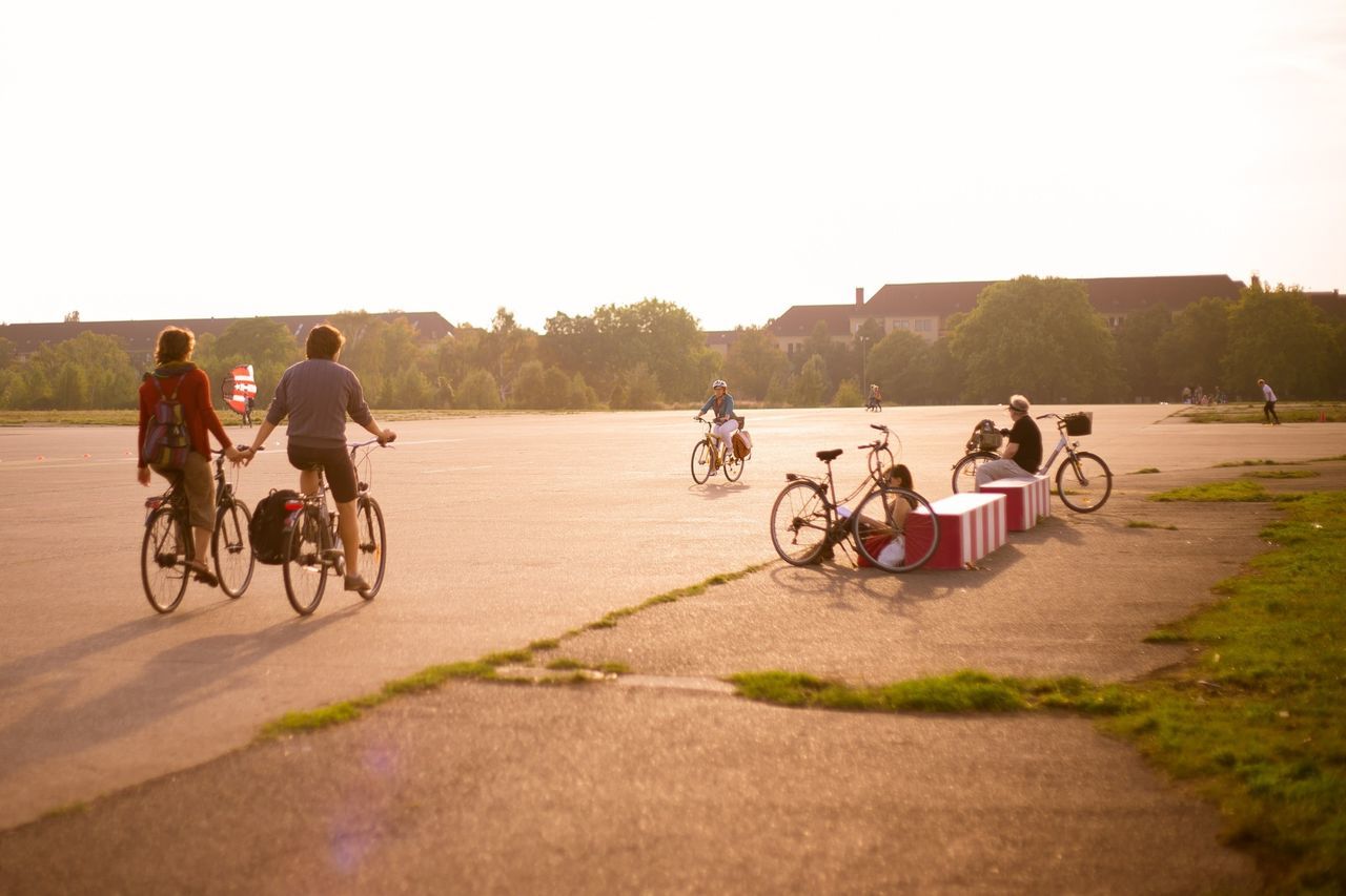 bicycle, land vehicle, riding, transportation, mode of transport, men, lifestyles, leisure activity, cycling, motorcycle, clear sky, working animal, full length, domestic animals, togetherness, on the move, person, grass, horse