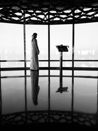 Rear view of man photographing through window