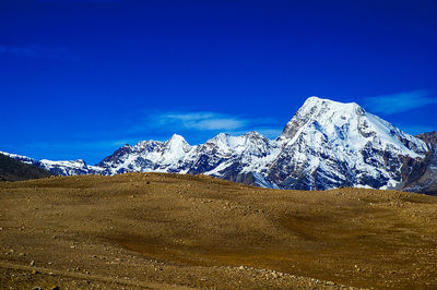 Scenic view of snowcapped mountain against blue sky