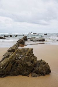 Rocks on beach against sky