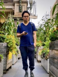 Portrait of young man standing against building