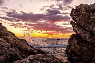 Scenic view of sea against dramatic sky during sunset