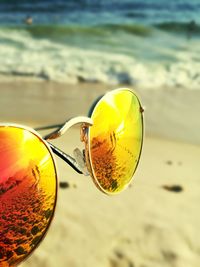 Close-up of sunglasses on sand