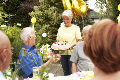 Mature woman serving birthday cake