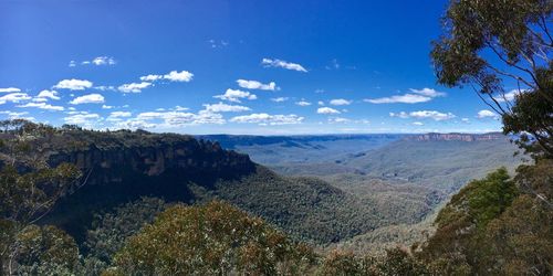 Panoramic shot of countryside landscape against blue sky