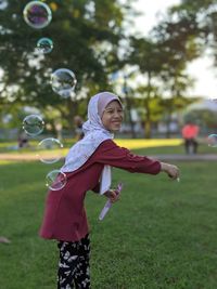 Rear view of girl playing with bubbles