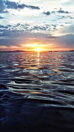 Reflection of clouds in sea at sunset