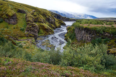 Scenic view of waterfall against sky