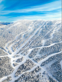 Aerial view of snow covered landscape against sky