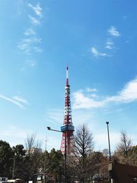 Low angle view of communications tower and buildings against sky