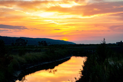 Scenic view of lake against orange sky