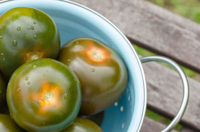 Close-up of unripe tomatoes in colander on table