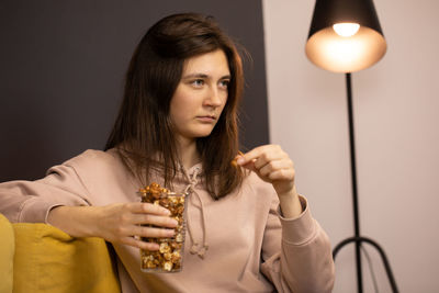 Portrait of young woman holding illuminated lamp