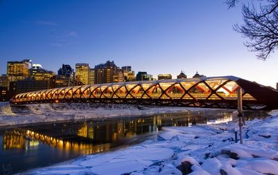Peace bridge over bow river against sky during winter