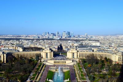 Aerial view of city buildings against blue sky