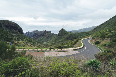 Road leading towards mountains against sky