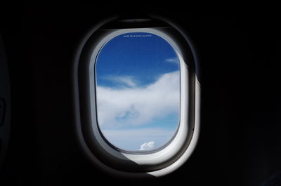 View of cloudy sky seen through airplane window